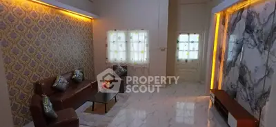 Elegant living room with stylish decor and ambient lighting, featuring marble accents and cozy seating.