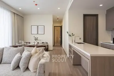 Modern open-plan living room and kitchen with elegant decor and natural light