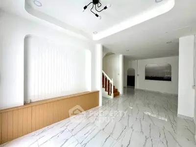 Spacious modern living room with elegant staircase and marble flooring