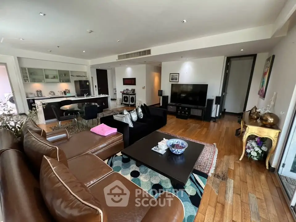 Spacious modern living room with leather sofa and open kitchen layout