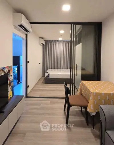 Modern studio apartment with sliding glass doors and cozy dining area