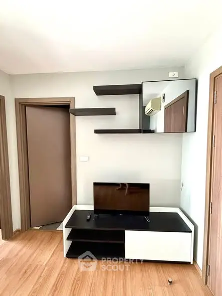 Modern living room with sleek TV stand and wall-mounted shelves, perfect for stylish urban living.