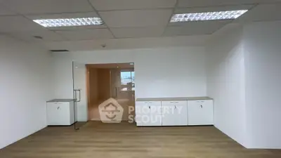 Spacious office interior with modern glass doors and ample storage cabinets.