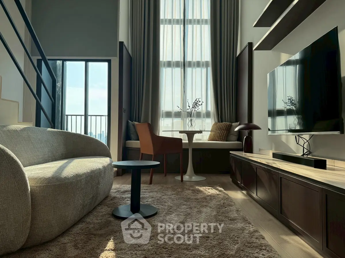 Modern living room with high ceilings, large windows, and stylish furniture in a luxury apartment.