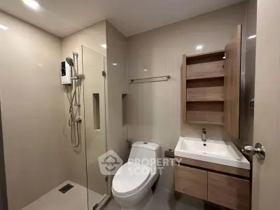Modern bathroom with glass shower, sleek fixtures, and wooden cabinetry.