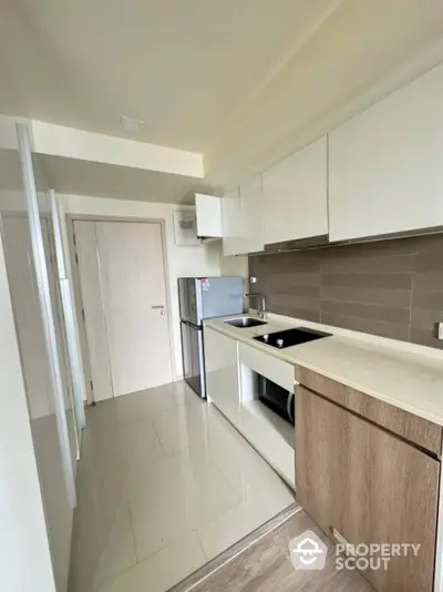 Modern kitchen with sleek cabinets and compact design in a contemporary apartment.