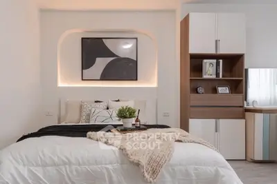 Modern bedroom with stylish decor and cozy bedding in a contemporary apartment.