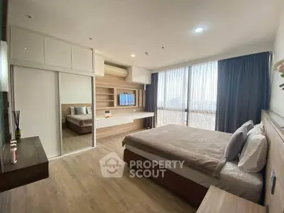 Spacious modern bedroom with large windows and stylish decor in a high-rise apartment.