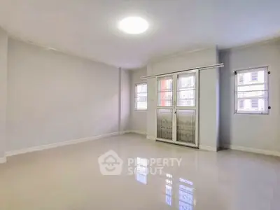 Spacious empty room with large windows and bright lighting