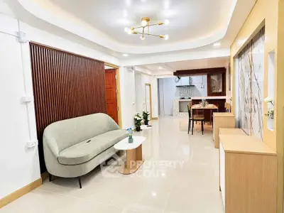 Spacious modern living room with elegant decor and open layout leading to dining area.