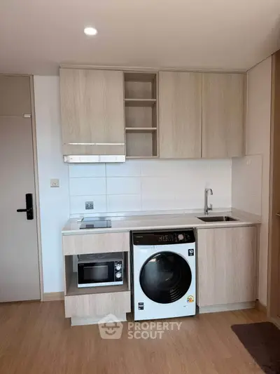 Modern compact kitchen with built-in appliances and sleek cabinetry