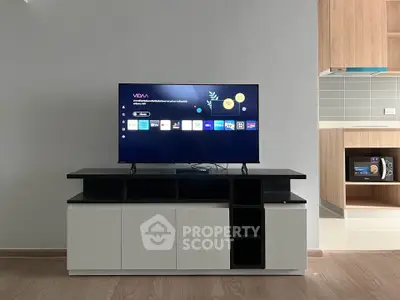 Modern living room with sleek TV stand and open kitchen layout