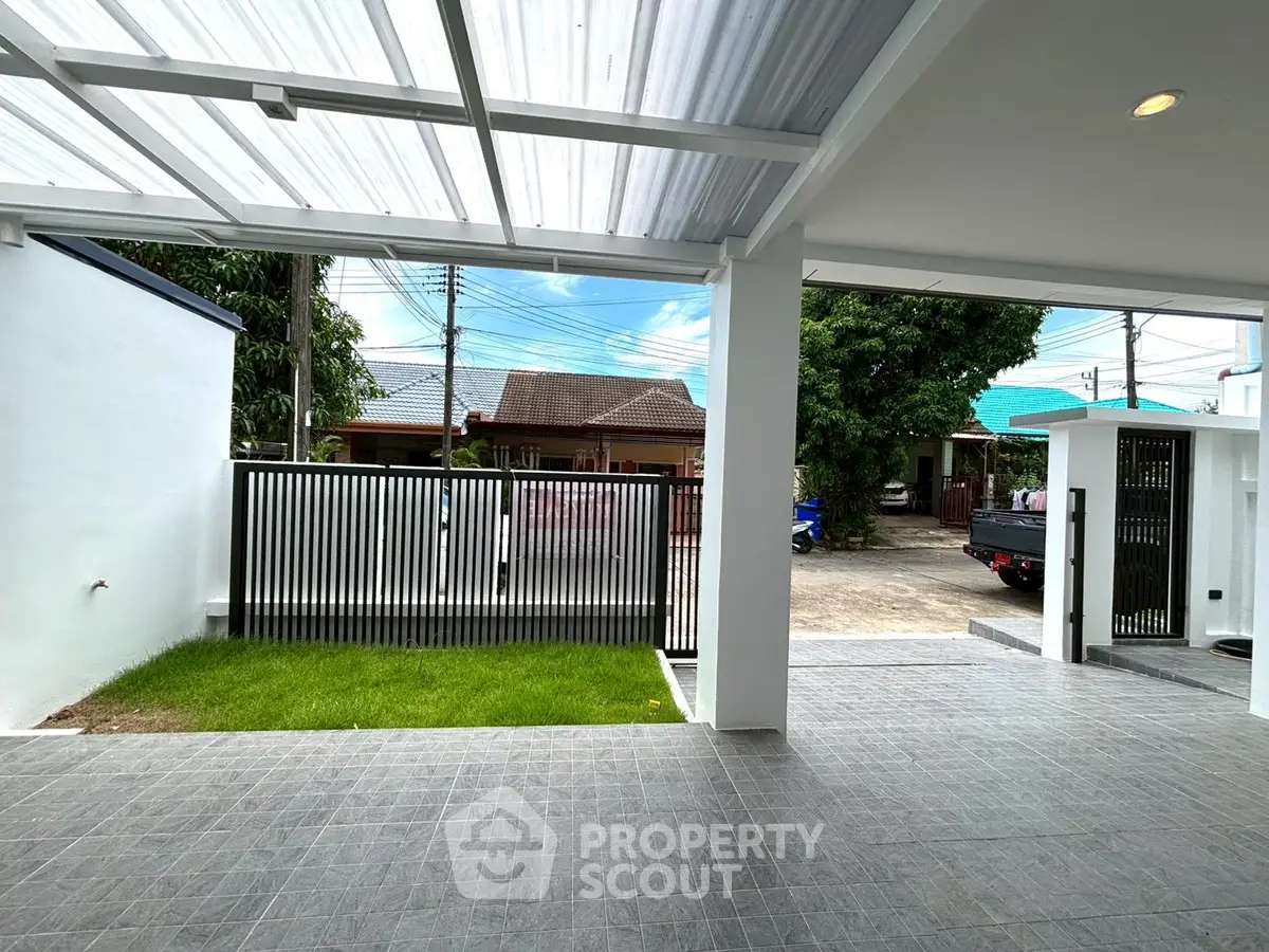 Modern home entrance with covered patio and lush green lawn, perfect for family gatherings.