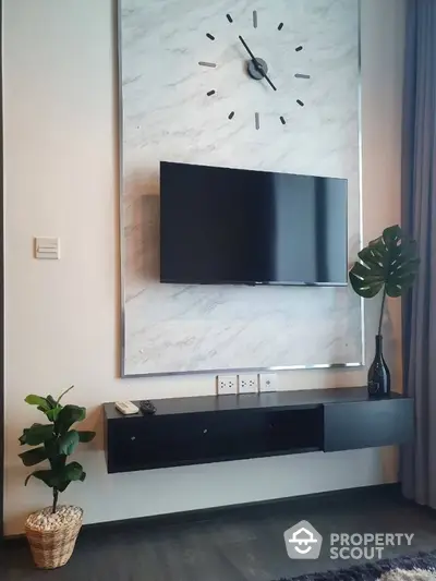 Stylish modern living room with wall-mounted TV and decorative clock