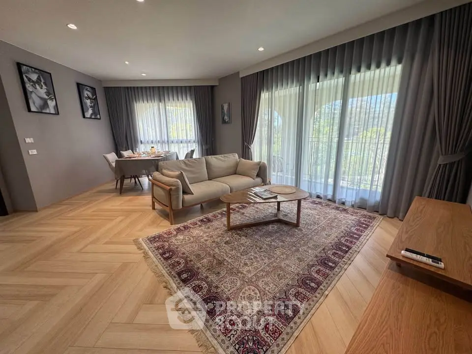 Spacious living room with elegant decor and large windows offering natural light.
