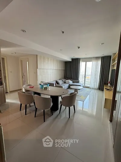 Spacious modern living room with elegant dining area and large windows offering natural light.