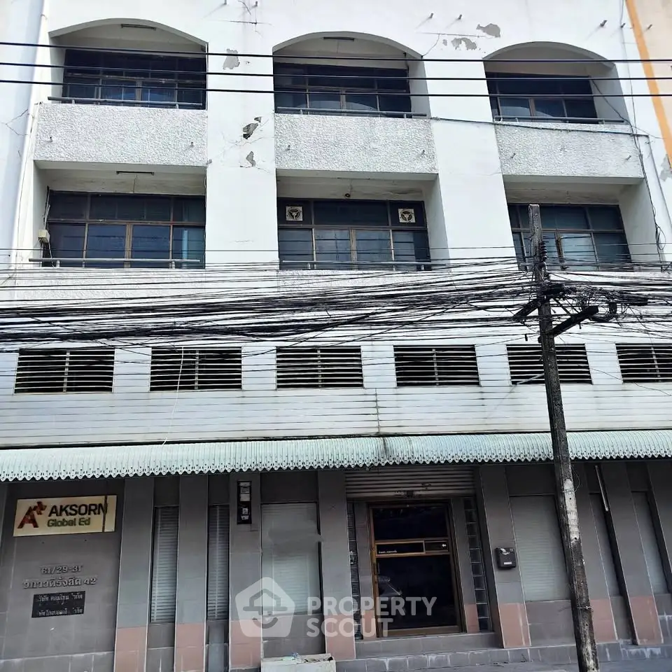 Charming vintage building facade with potential for renovation in a bustling urban area.
