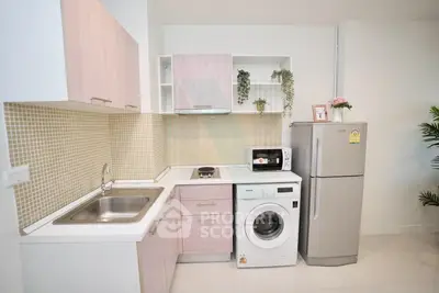 Modern kitchen with sleek appliances and stylish cabinetry in a compact layout.