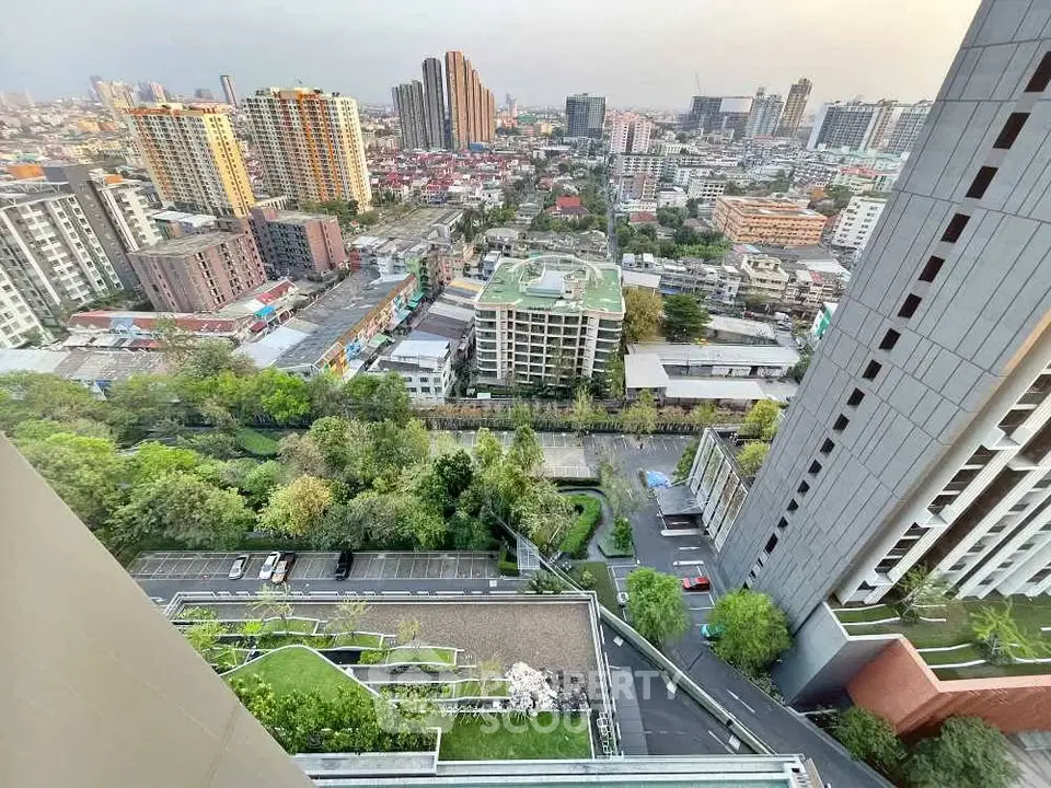 Stunning cityscape view from high-rise building with lush greenery and urban skyline.