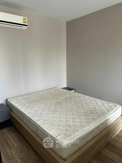 Cozy bedroom with modern air conditioning and wooden flooring