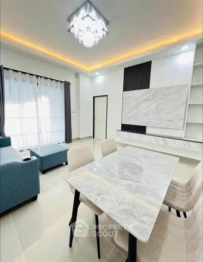 Modern living room with elegant dining area and stylish lighting, featuring marble accents and contemporary furniture.