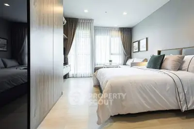 Spacious modern bedroom with elegant decor and large windows for natural light.
