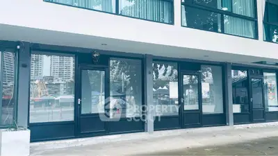 Modern commercial building exterior with large glass windows and doors, ideal for retail or office space.