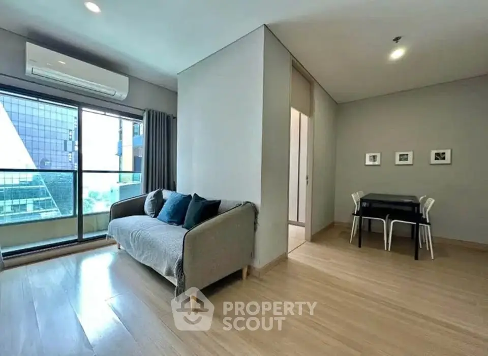 Modern living room with large windows and stylish furniture in a high-rise apartment.