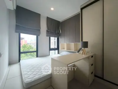Modern bedroom with large windows and sleek furniture in a stylish apartment.