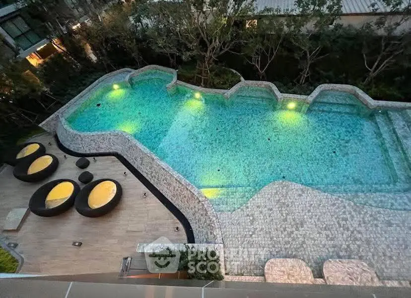 Luxurious outdoor pool with stylish seating area in modern residential complex