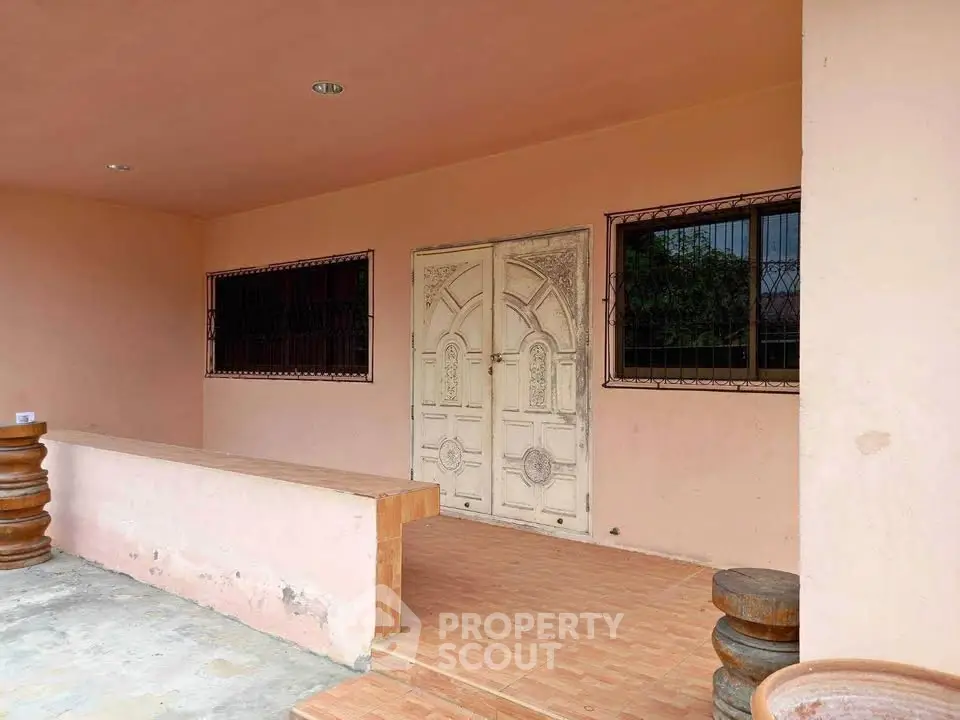 Charming rustic entrance with vintage doors and terracotta tiles, perfect for a cozy home.