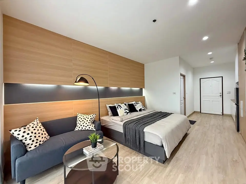Modern bedroom with stylish decor and cozy seating area in a contemporary apartment.