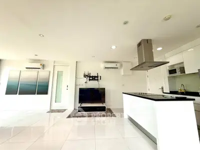 Spacious modern living room with open kitchen and sleek white finishes