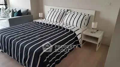 Modern bedroom with stylish striped bedding and cozy ambiance