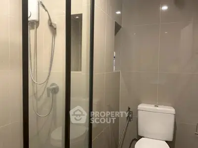 Modern bathroom with sleek shower and toilet in contemporary design.