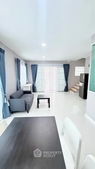 Spacious modern living room with elegant decor and large windows for natural light.