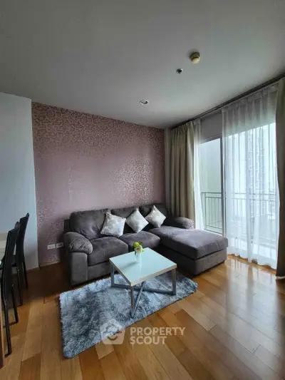 Modern living room with stylish decor and large windows offering natural light.