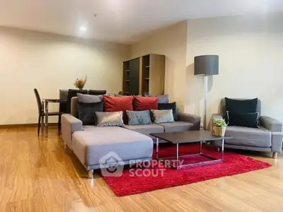 Spacious living room with modern furniture and vibrant red accents