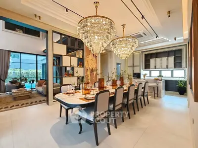 Luxurious open-plan dining and living area with elegant chandeliers and modern decor.