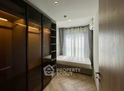 Modern bedroom with sleek wardrobe and large window for natural light