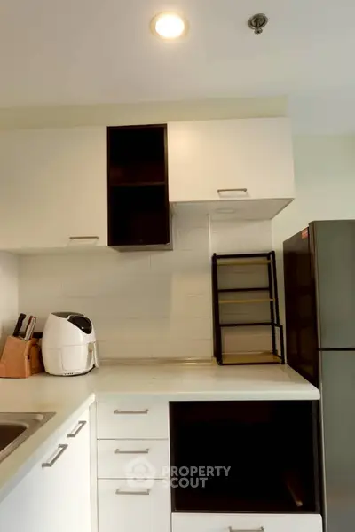 Modern kitchen with sleek white cabinets and stainless steel appliances