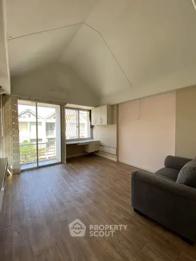 Spacious living room with high ceiling and large window view