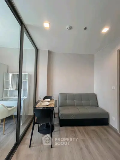 Modern living room with sleek furniture and glass partition in a stylish apartment.