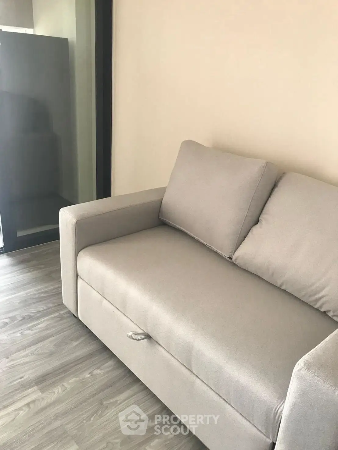 Modern living room with sleek gray sofa and wooden flooring