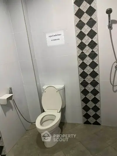 Modern bathroom with sleek tile design and convenient shower setup.