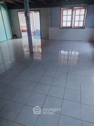 Spacious tiled room with large windows and natural light