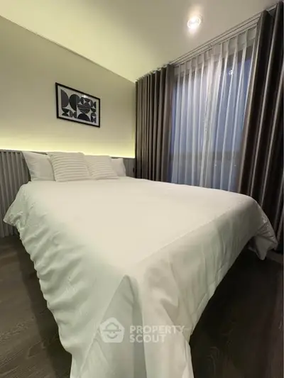 Modern bedroom with elegant decor and ambient lighting, featuring a comfortable bed and stylish curtains.