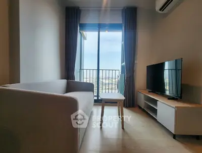 Modern living room with balcony view, sleek furniture, and natural light.
