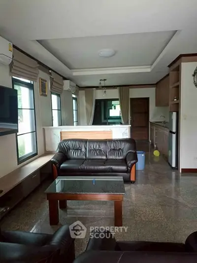 Spacious living room with modern furniture and open kitchen layout