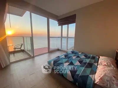 Stunning ocean view bedroom with floor-to-ceiling windows and balcony access.